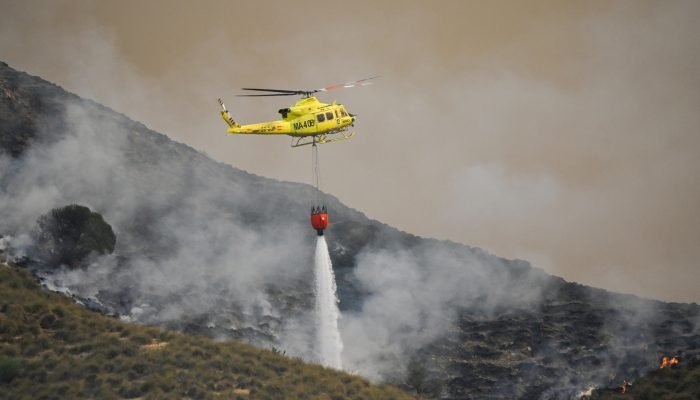 Helicóptero joga água para combater as chamas em Los Gallardos nesta sexta-feira (10) (Foto: Ca...