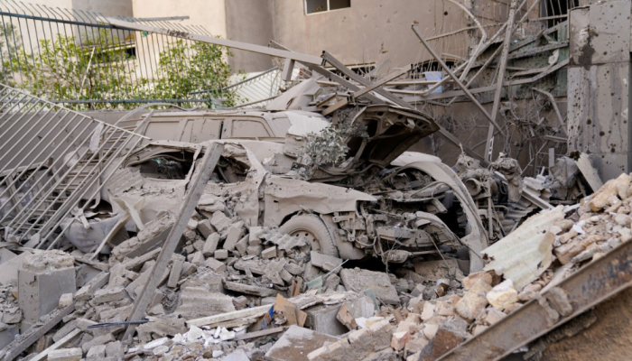 Escombros e destroços cobrem um veículo destruído após um ataque com mísseis a um bairro de ...