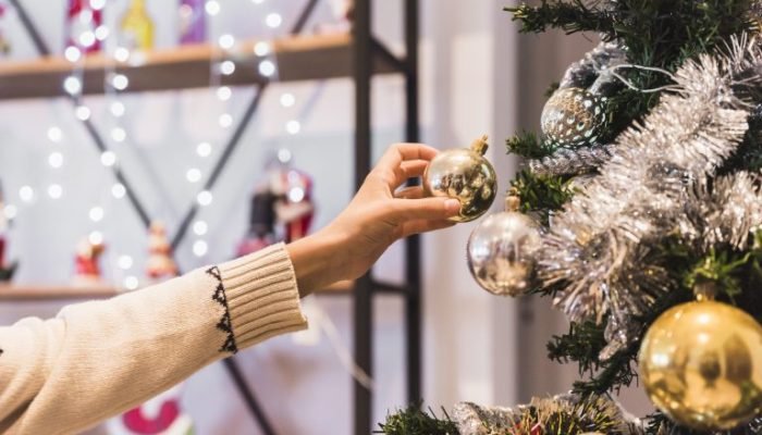 mao-com-ornamento-bauble-perto-arvore-natal-768x513