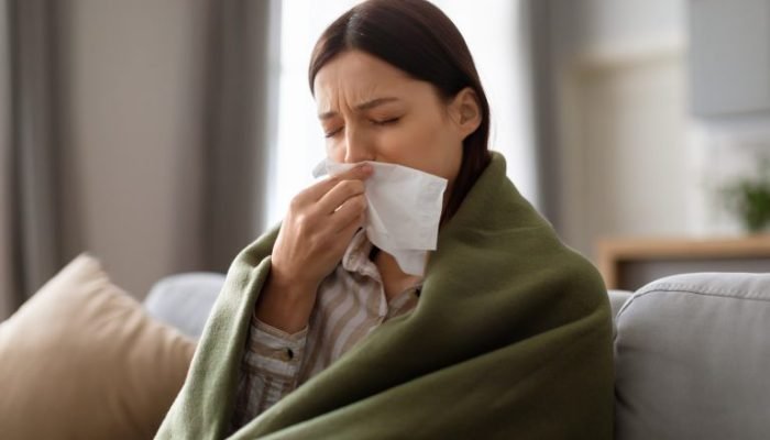 sick-young-woman-wrapped-blanket-blowing-her-nose-768x512